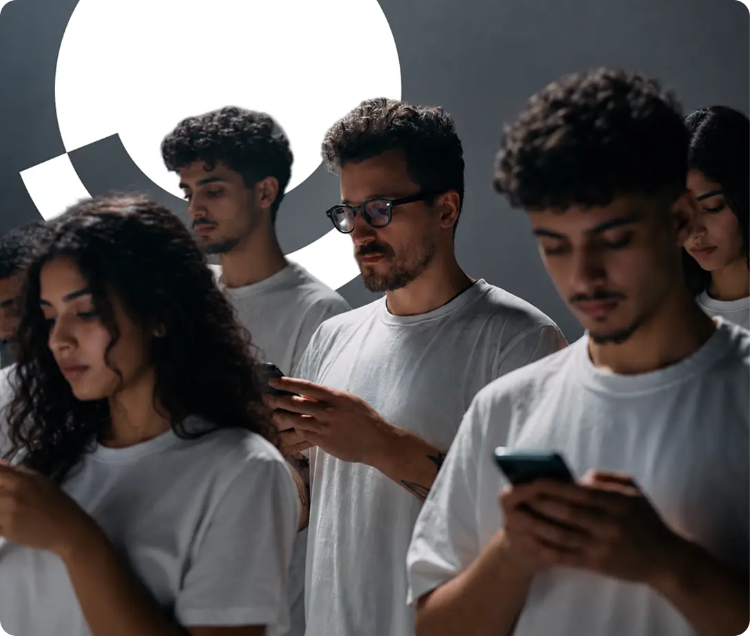 People in white T-shirts looking at their phones